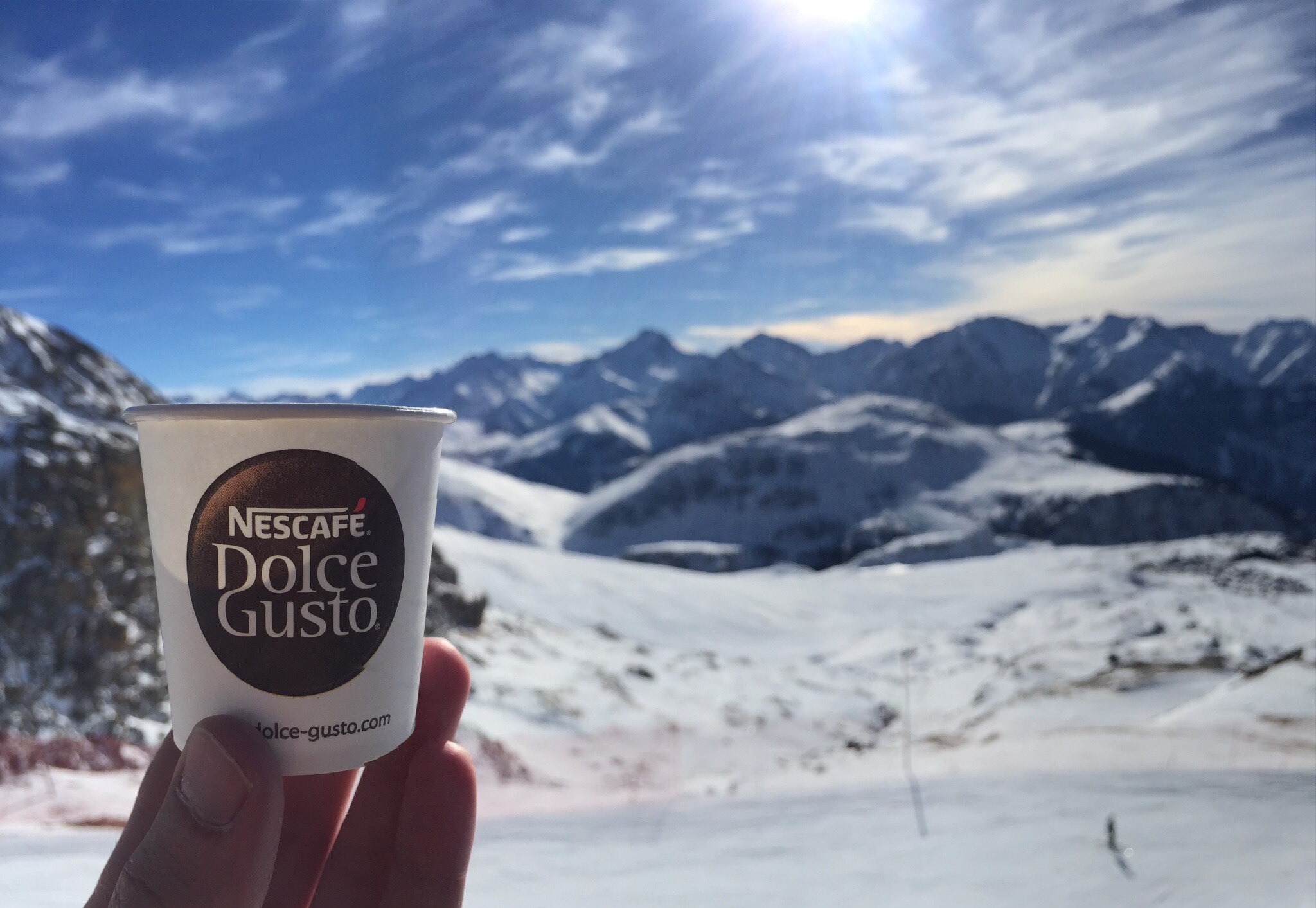 Tasse de café NESCAFE Dolce Gusto® dans le décor des montagnes de l’Alpe d’Huez